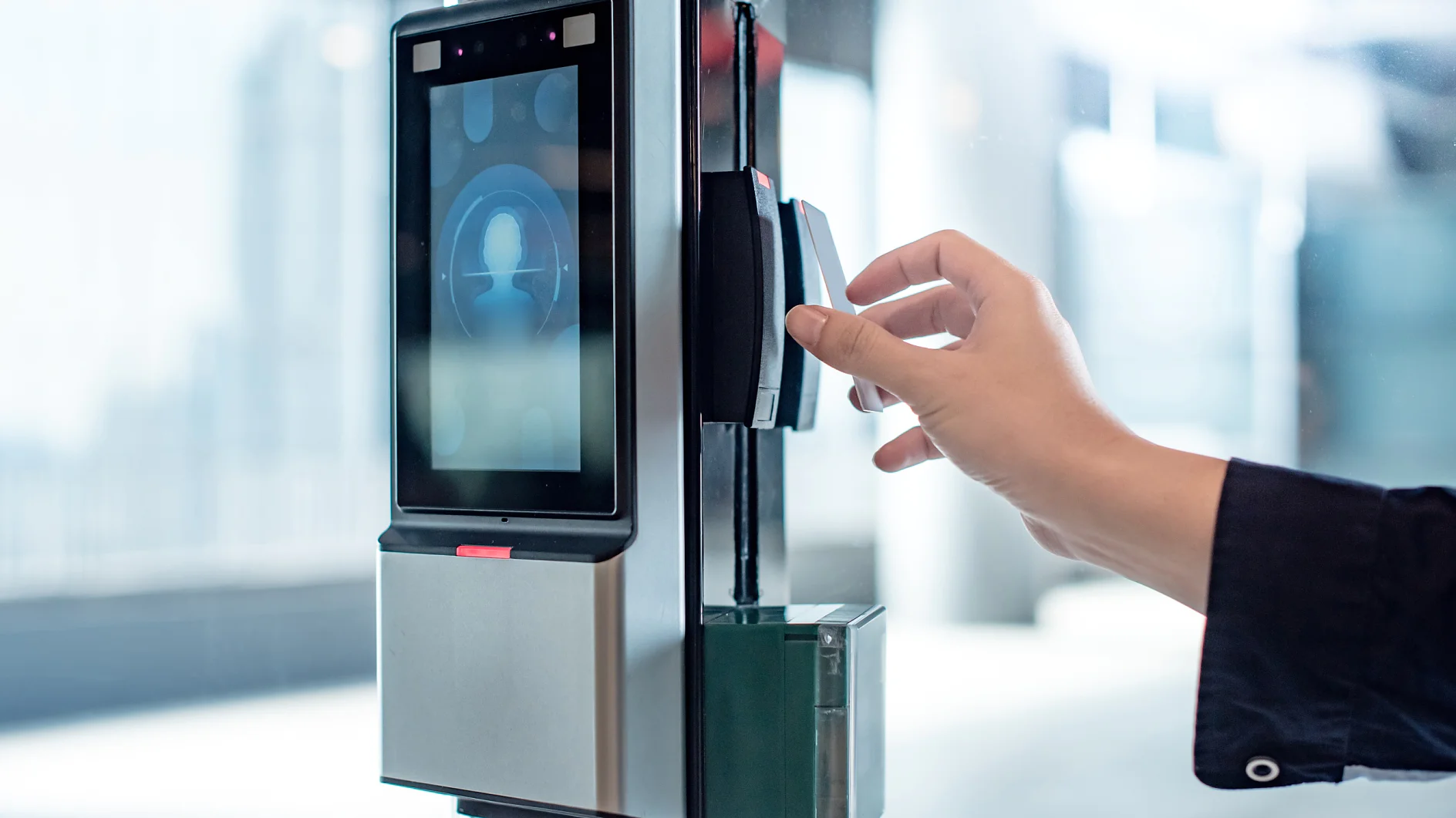 Male hand using key card to open smart door lock for security system on glass door in office building. Biometric authentication device for privacy and safety.