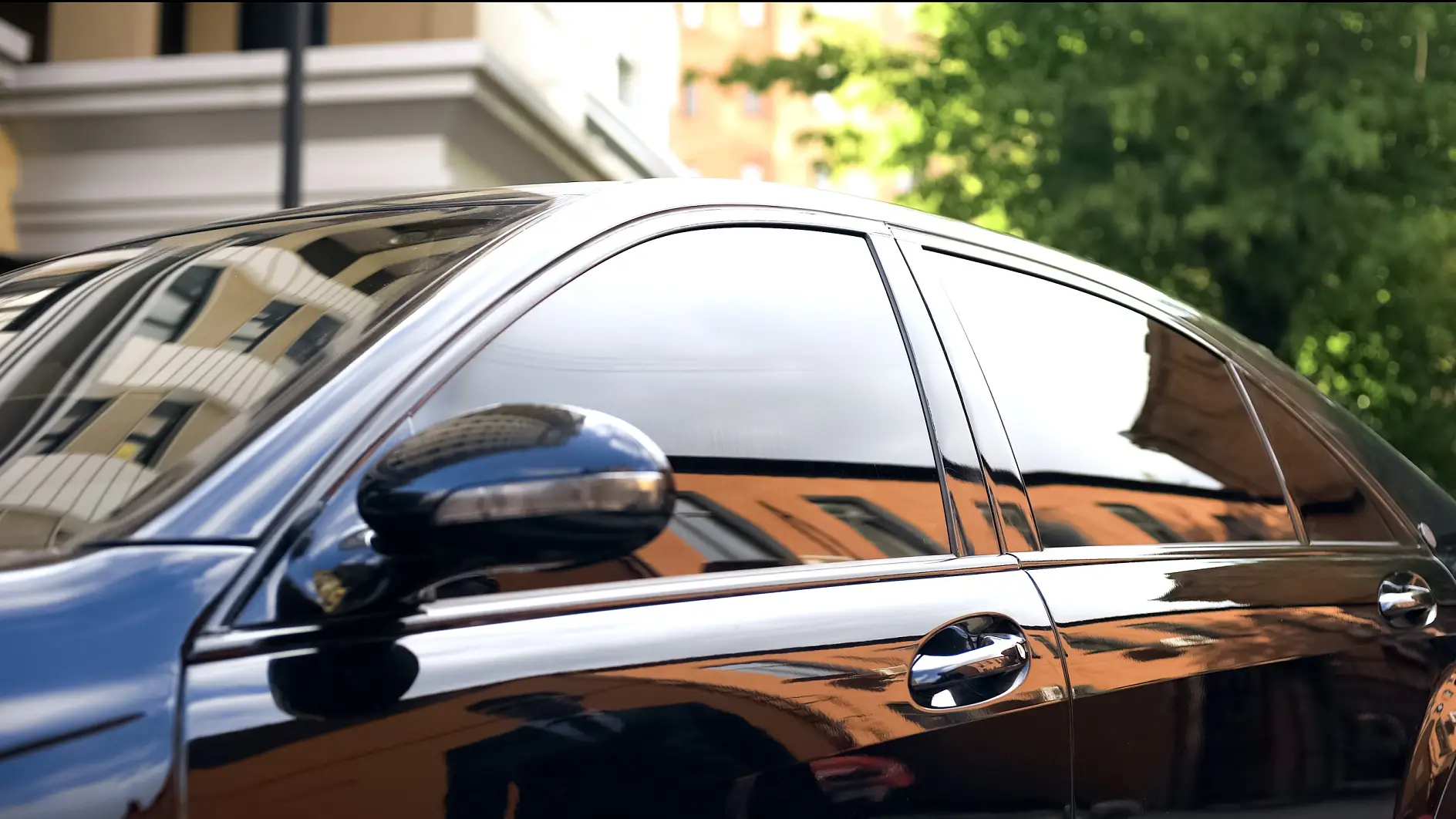 Luxury car with tinted glass standing at parking, reflection of businessman