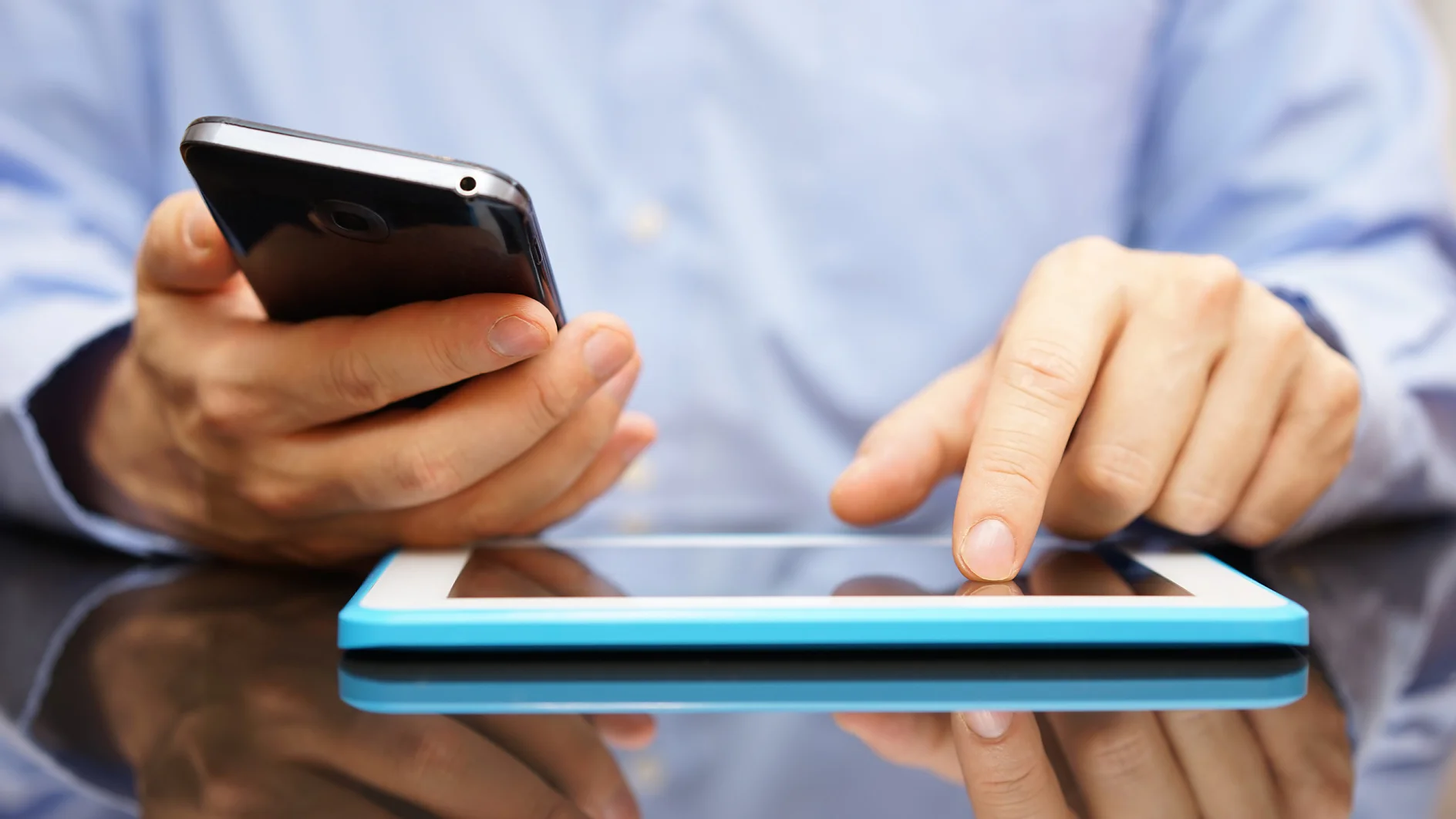 male is using smart mobile phone and tablet computer at the same time