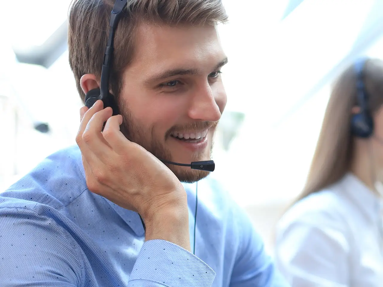 Portrait d'un employé de centre d'appel accompagné de son équipe. Opérateur de support client souriant au travail.