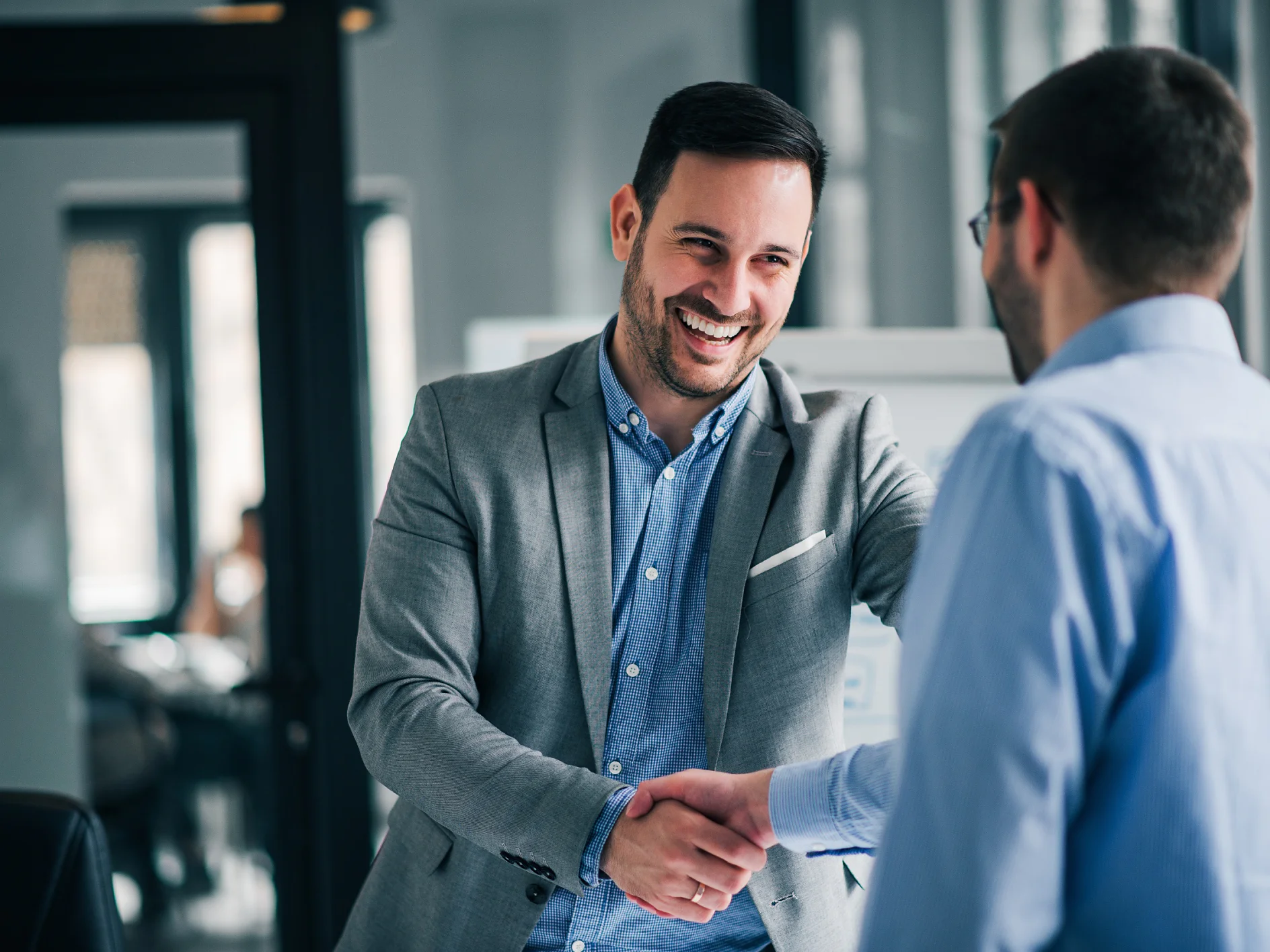 Portrait of cheerful young manager handshake with new employee. 