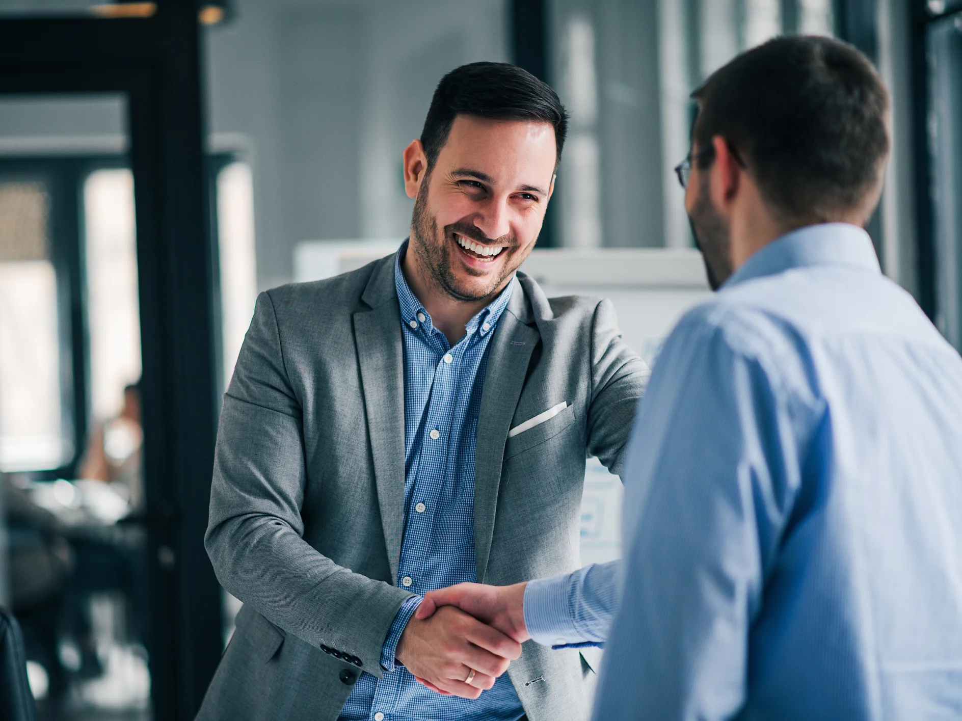 Portrait of cheerful young manager handshake with new employee.