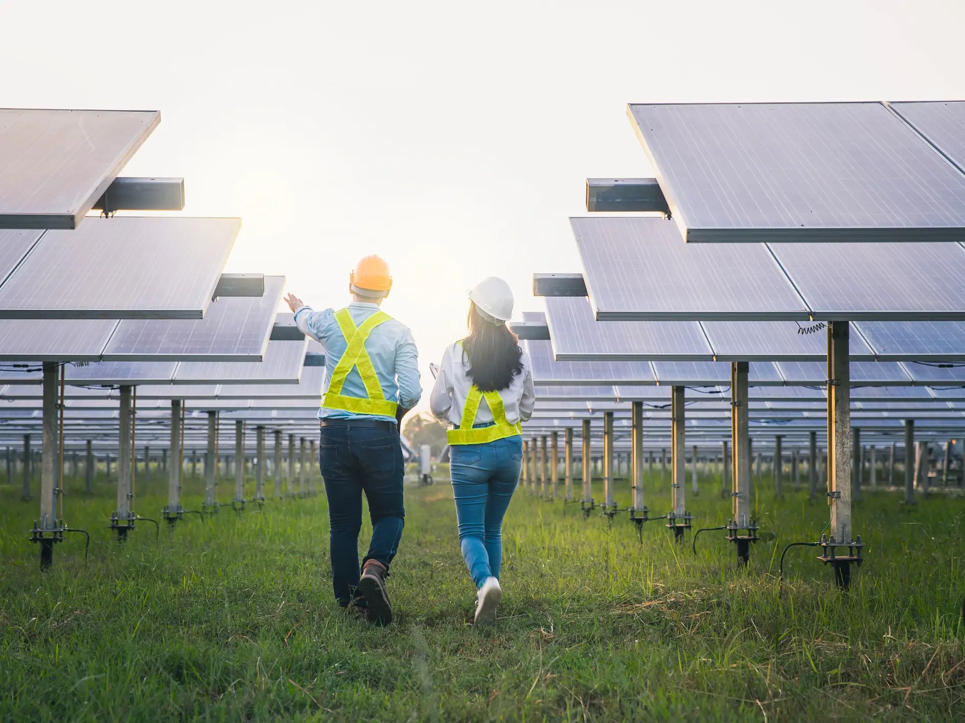 Erkek ve kadın çalışan bakım panelleri güneş enerjisi toplarken. Güneş enerjisi endüstrisinde kontrol ve bakım ekipmanları üzerinde çalışan mühendis.